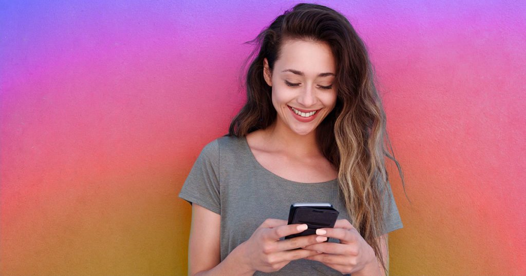 Girl smiling while using phone; What is the best time to post on Instagram on Monday