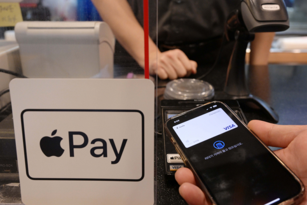 Person paying with Apple Pay; Inside The Apple Pay Glitch 2023: Causes And Solutions