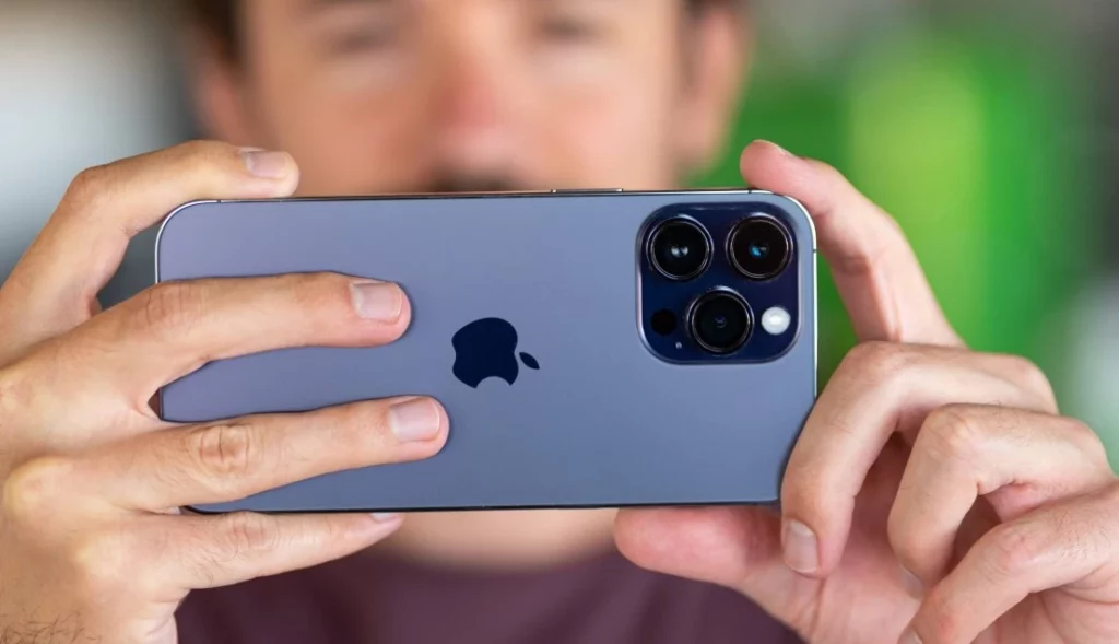 A person capturing a picture with an iPhone 14; What is Raw Max in iOS 17 - Get The Full Picture Here?