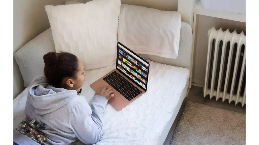 A girl watching laptop; How to Fix Netflix Error 1018