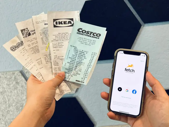 A man carrying receipts in one hand and fetch app opened in phone in another; Fetch Daily Reward Not Showing Up - Here Is How To Recover It In 8 Steps